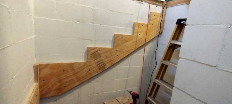 stringer fixed to basement wall